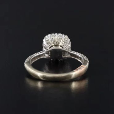 A silver ring with a detailed design, viewed from the side.