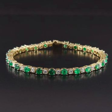 Elegant gold bracelet with green and white gemstones.