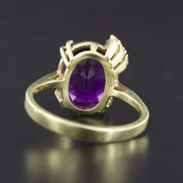 Gold ring with an oval purple gemstone.