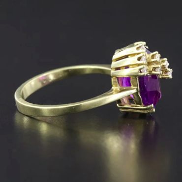 Gold ring with purple gemstone and diamonds.