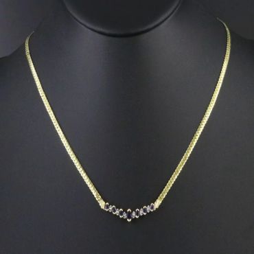 Elegant gold necklace with small gemstones.