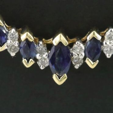Close-up of a sapphire and diamond gold necklace.