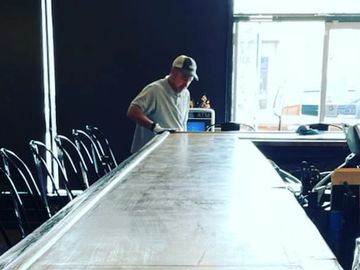 Workers applying a ceramic coating onto a bar table
