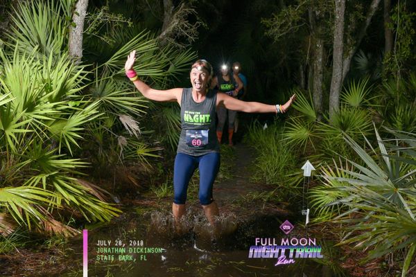 A lady running in the trails at Jonathan Dickinson State Park during the 10 Night trail run