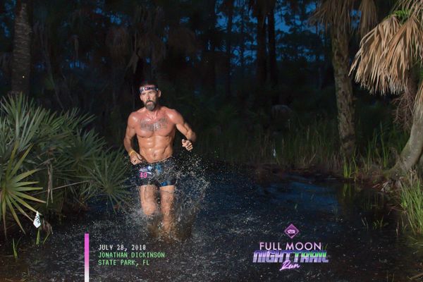 a person running a trail race in the dark.