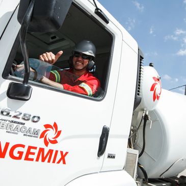Worker gives thumbs up from cement mixer truck window.