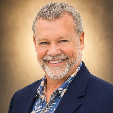 Smiling middle-aged man with gray hair and beard in a blue blazer.