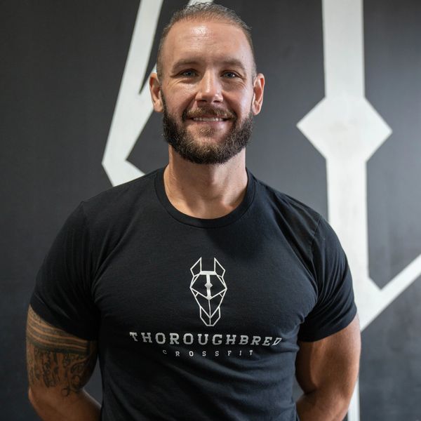 Smiling man in a black Thoroughbred CrossFit t-shirt.