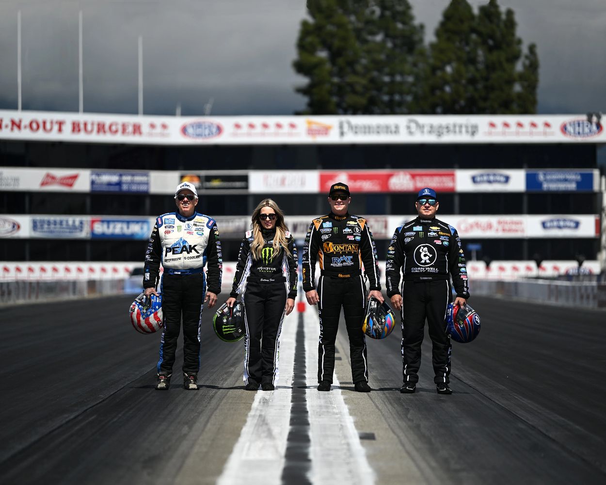 John Force Racing Drivers walking down the race track. L to R: John, Brittany, Austin, and Robert.