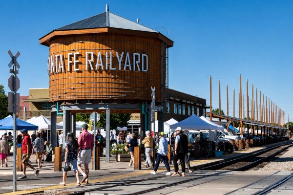 Santa Fe Railyard with people walking and market stalls.