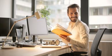 man mindful journaling at work to improve his mental health as he lives with anxiey, depression.