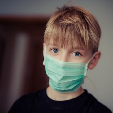 Boy with OCD wearing a mask showing the significance of mental health therapy for OCD self care.