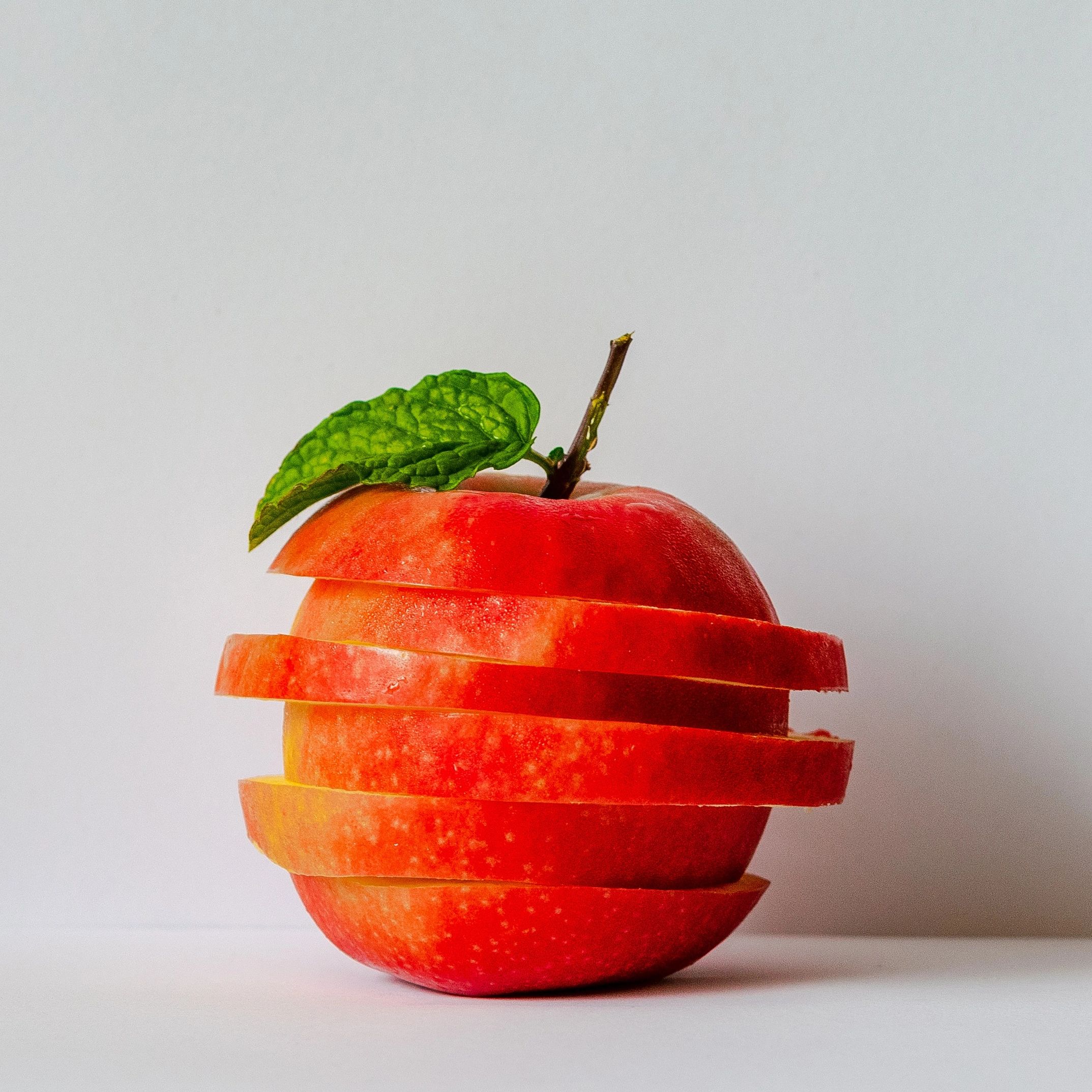 sliced red apple, representing food that is great for mental health, self-care, healthy living.