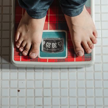 Eating disorder recovery: The power of mental health therapy. Person standing on scale.