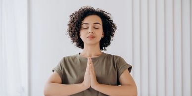 Woman in prayer position doing a gratitude practice to help decrease anxiety, stress, and pain.