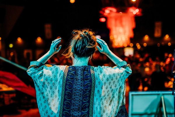 Woman at an event worshiping seen from behind.