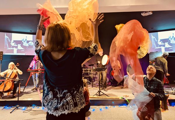 Creative worship with fabric moving captured in front of musicians