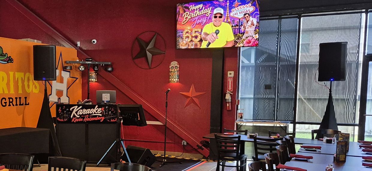 Karaoke setup inside a restaurant with birthday message on TV.