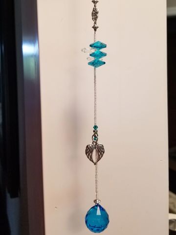 Suncatcher with teal blue crystal and angel wing charm. 