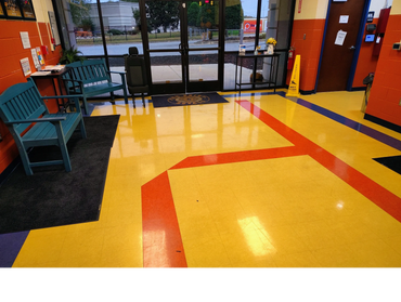 Colorful lobby with benches and a glass door entrance.