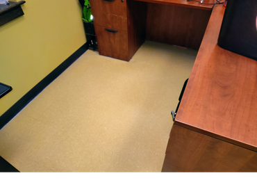 Office corner with wooden desks and yellow walls.