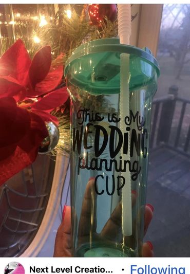 Transparent cup with teal lid saying 'This is my wedding planning cup'.