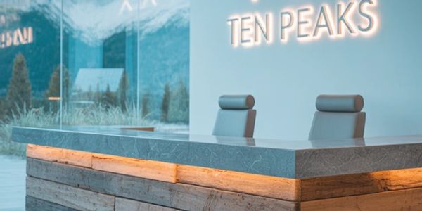 Modern reception desk with mountain view and Ten Peaks sign.