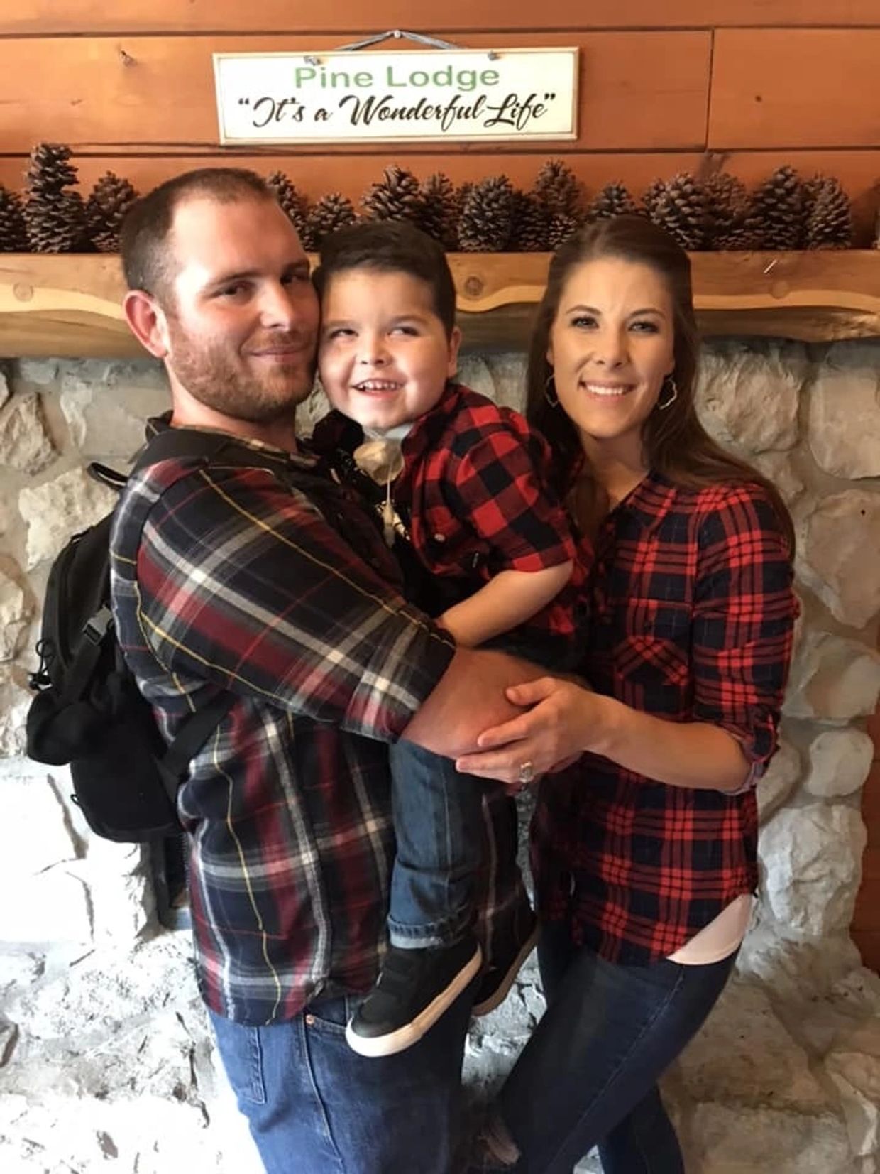 A happy family in matching plaid shirts at Pine Lodge, smiling warmly.