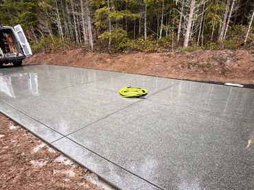 Newly polished concrete driveway with a white van in the background.