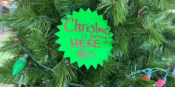 Christmas tree sign announcing Christmas arrival on 11/25.