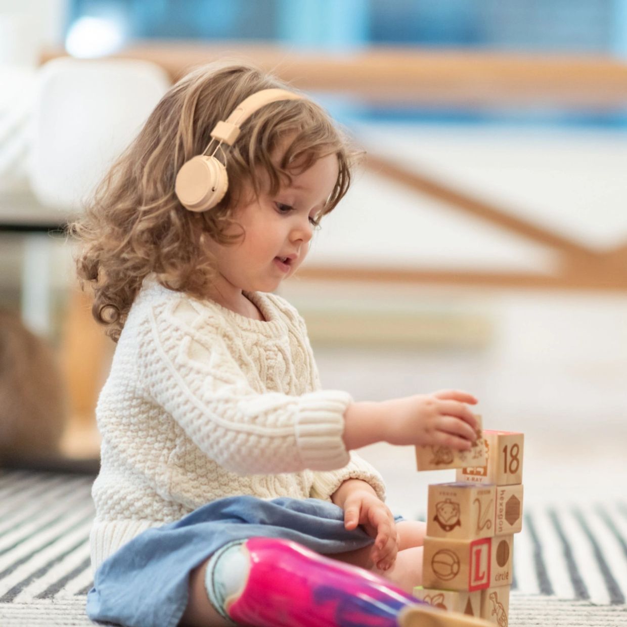 Girl playing with blocks whilst listening to RRP