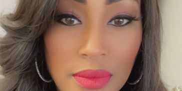 Close-up of a woman with bold makeup and hoop earrings.
