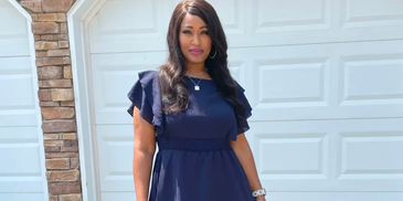 Woman in a navy blue dress standing in front of a white garage door.