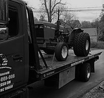 Farm tractor and construction equipment being towed and transported in Worcester, MA by American Tow