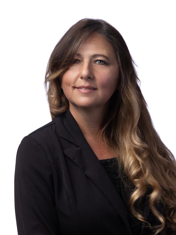 Professional woman with long curly hair and a black blazer.