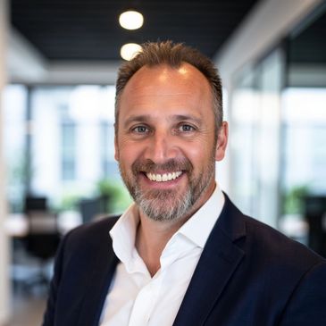 Smiling man in business attire in a modern office setting.
