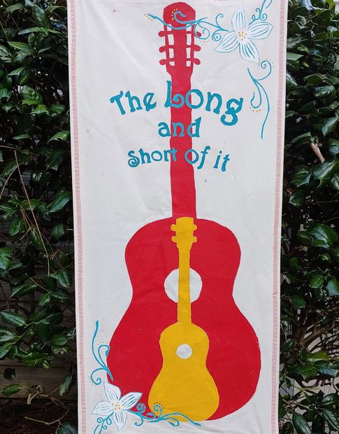 Canvas banner with red guitar silhouette. Yellow ukulele silhouette in front. "The Long and Short of