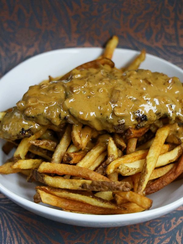 Plate of fries topped with steak and gravy.