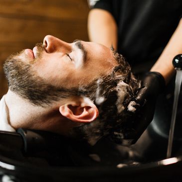 gentleman receiving a hair cleansing service at a shampoo bowl