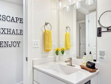 Bright bathroom with yellow accents and clean white decor.