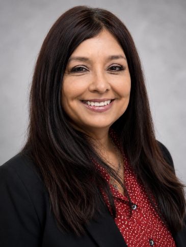 Professional woman smiling in business attire.