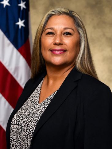 Professional woman with an American flag in the background.
