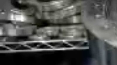 Close-up of a polished stainless steel industrial component with multiple flanges and connectors.