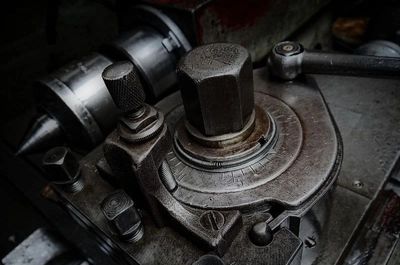 Close-up of an old, rusty mechanical dial with textured metal parts.