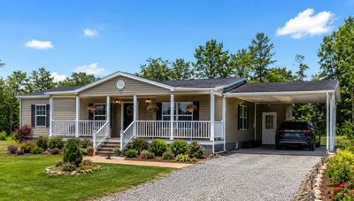 Single-story house with a front porch and carport on a sunny day.