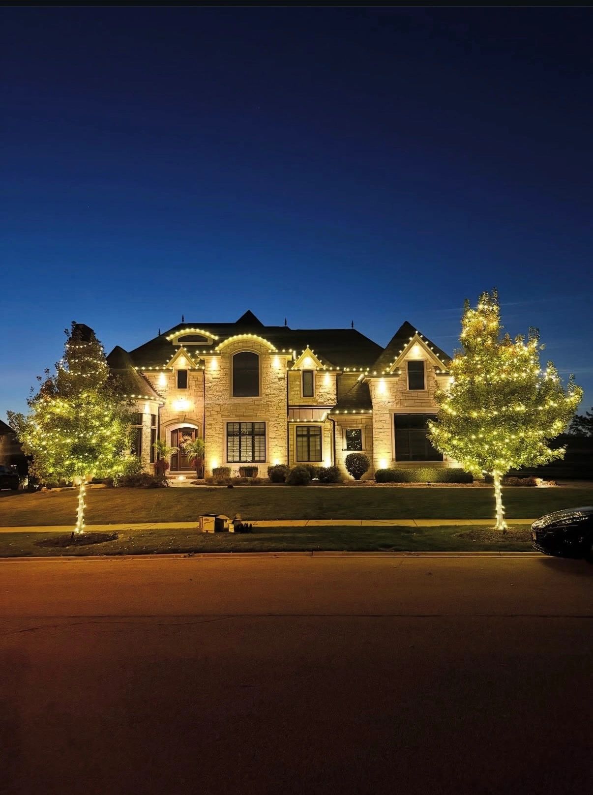 Elegant house decorated with warm yellow lights at night.