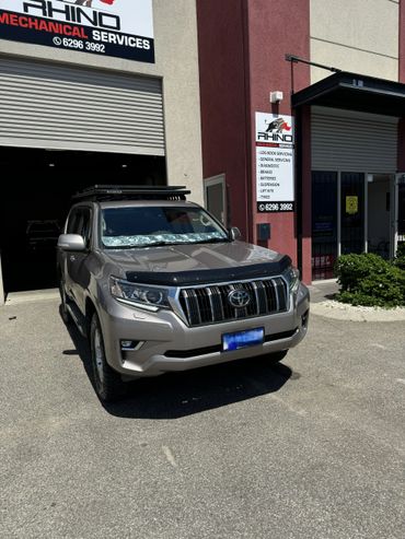 Toyota SUV parked outside Rhino Mechanical Services workshop on a sunny day.
