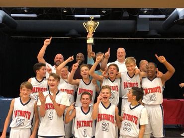 Youth basketball team celebrating with a trophy.