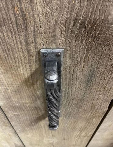 Riveted hand-forged wrought iron door handle with unique twist technique