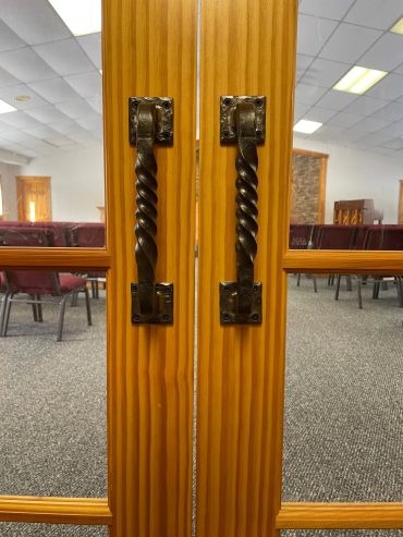 Custom hand-forged wrought iron door handles for double swing church entry door